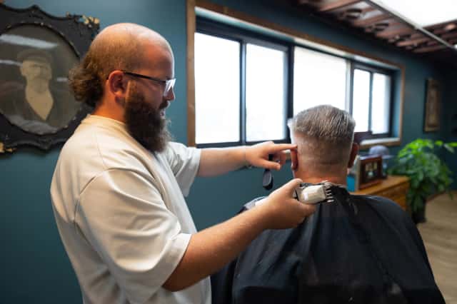 Skilled barber Sheldon providing precision haircut at Cache Cuts Logan Utah barbershop