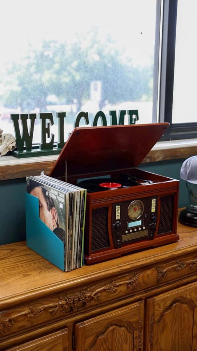 Vintage record player and vinyl collection at Cache Cuts Logan Utah barbershop lounge