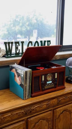 Vintage record player and vinyl collection at Cache Cuts Logan Utah barbershop lounge — Classic vinyl records and vintage player creating authentic barbershop ambiance in Logan
